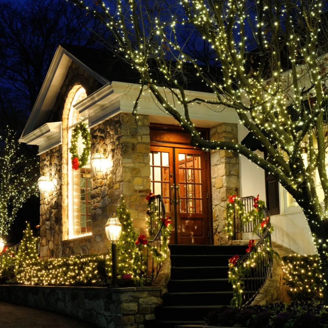 Stone-front home with festive LED garland and lights installed by LiteXcite